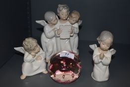 Three Lladro choral/Angel figurines and a scottish paperweight.