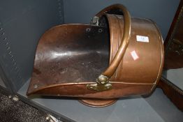 A copper and brass coal bucket .