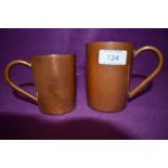 A pair of vintage copper mugs, one small and the other larger.