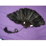 A late 19th/early 20th century black ostrich feather fan,a little wear in places and could do with