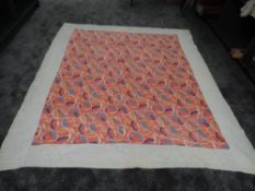 A large vintage quilt having bright pattern with coral,blues and yellows to centre, around a double,