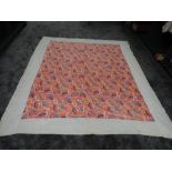 A large vintage quilt having bright pattern with coral,blues and yellows to centre, around a double,