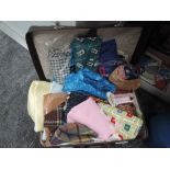 A suitcase containing an array of vintage fabrics, predominantly 50s and 60s, some still in original