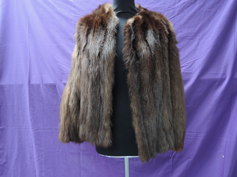 A short vintage fur jacket having leather inserts to back of arms, fully lined and in soft and