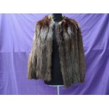 A short vintage fur jacket having leather inserts to back of arms, fully lined and in soft and