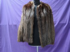 A short vintage fur jacket having leather inserts to back of arms, fully lined and in soft and