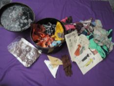 A metal sailors hat tin containing an assortment of 50s dress patterns, stockings,scarves and