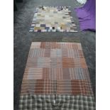 Two vintage quilts, mostly made up of square and rectangular sections of wool and backed in cotton,a