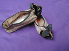 A pair of vintage children's slippers or shoes having oriental styling and rabbit faces to toes in