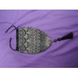 An early 20th century drawstring evening bag having extensive beadwork in black,silver and gold with