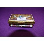 A hard paste continental trinket box hand decorated with mythical cherub and sea beast