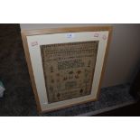 An intricate needle work sampler dated 1835 depicting alphabet with animal, plant characters and