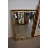 A bevel edged mirror with plaster style frame