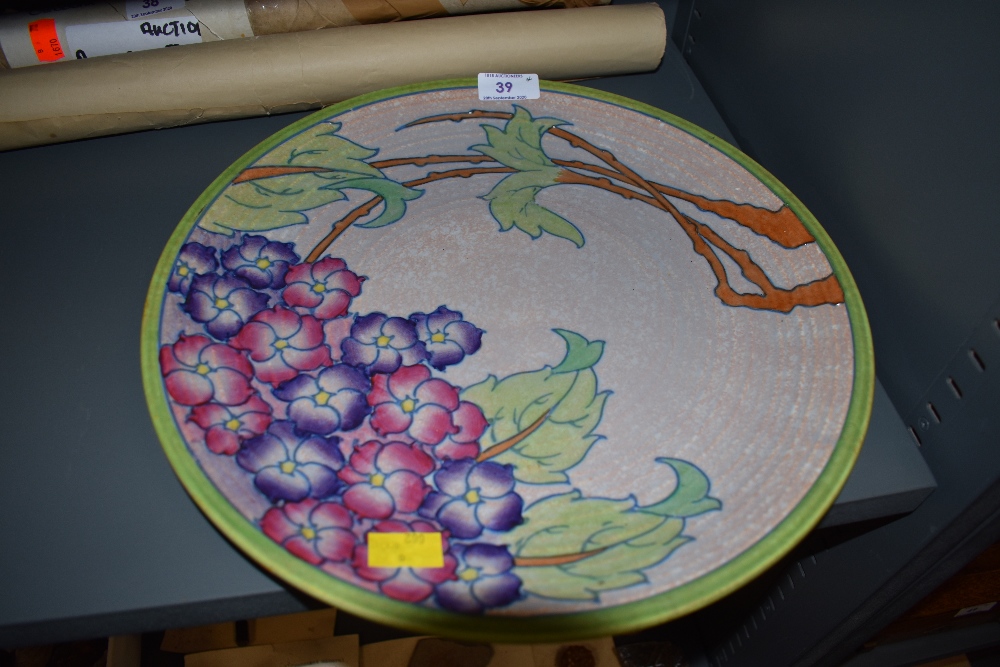 A large Art Deco styled charger plate by Charlotte Rhead depicting tree in bloom signed and