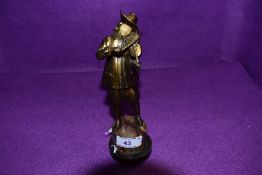 A metal cast figure with bronzed effect of a violinist on stone turned base