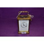 A brass cased carriage clock having enamel face dial and bevel edged glass with chime