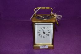 A brass cased carriage clock having enamel face dial and bevel edged glass with chime