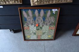 A rabbit needlepoint in frame.