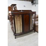 An early to mid 20th Century mahogany display cabinet, on ball and claw feet, central enclosed