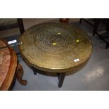 A traditonal Indian brass top coffee table on plain wood frame, diameter approx. 60cm