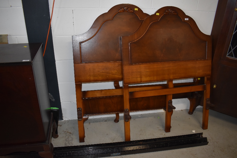 A pair of mid 20th Century mahogany and walnut single bed frames