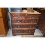 A 19th Century oak chest of two over three drawers, hvaing carved draw fronts and brass ring