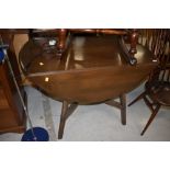 A dark stained Ercol drop leaf table and set of six moustache back chairs