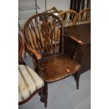 A traditional oak wheelback armchair, width approx 56cm