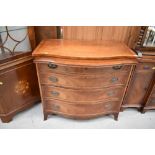 A Reprodux reproduction yew wood serpentine front chest of four drawers, and brushing slide, width