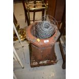 A traditional clay chimney pot and part roll of fencing wire