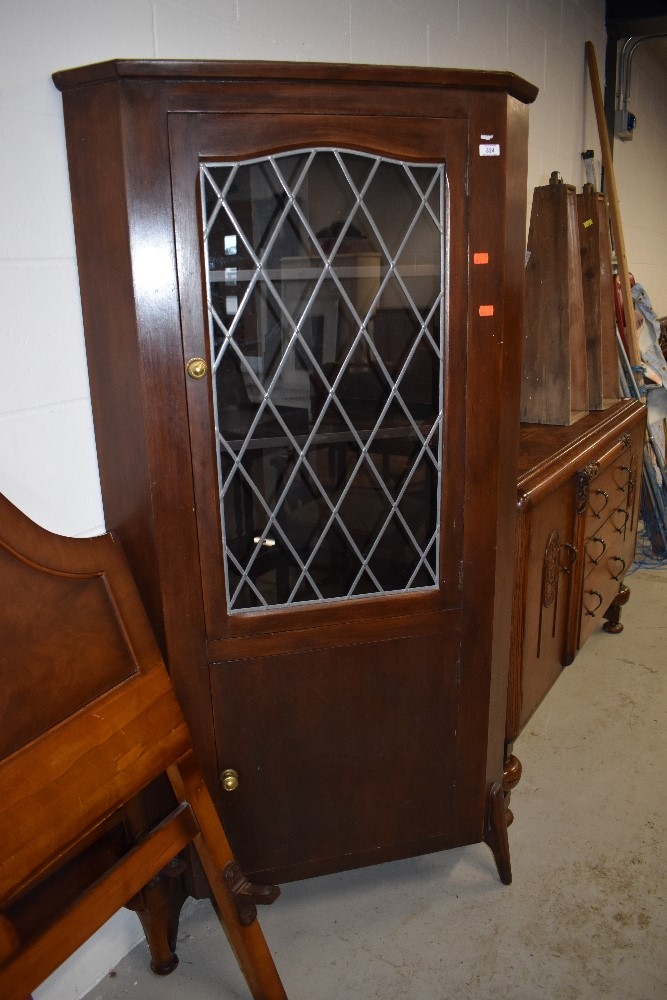 An early 20th Century stained frame corner display with lower cupboard section