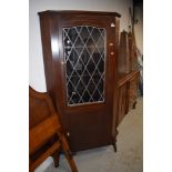 An early 20th Century stained frame corner display with lower cupboard section