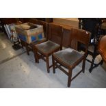 A set of four mid 20th Century oak dining chairs, having velvet upholstered seats and solid backs