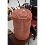 A vintage Lloyd Loom style dome top linen basket, in salmon pink