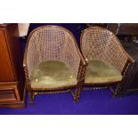 A pair of early 20th Century canework tub chairs having oak twist frames