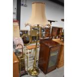 An Edwardian brass standard lamp, on swag column and triple claw footed base