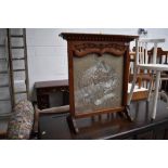 A mahogany framed firescreen having Oriental style silkwork inset