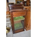 A late 19th or early 20th Century mahogany music cabinet having lift top, glazed door and lined