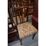 A pair of early 20th Century oak dining chairs having shaped slat backs and stuffed seats, real nice
