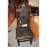 A Jacobean style oak hall chair having detailed dragon and angel leather work to seat and foliate