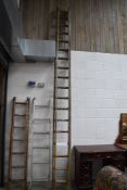 A large set of vintage wooden extending ladders