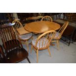 A beautiful Ercol extending table and set of four hoop and stick back chairs, gold badged, length