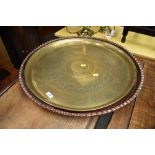 An indian style brass tray, diameter approx. 57cm and an Arts and Crafts style copper tray, having