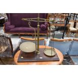 A set of vintage brass balance scales, on mahogany base