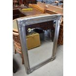 A hall way mirror having decorative silver frame