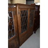 An oak display cabinet having leaded light doors and under compartment