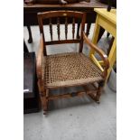 A 19th Century spindle back rocking chair having strung seat and turned frame