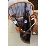 An Edwardian oak framed stick stand with a selection of walking sticks and umbrellas