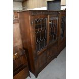 An oak display cabinet having leaded light doors and under compartment