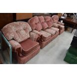 A modern pink dralon and floral three piece lounge suite